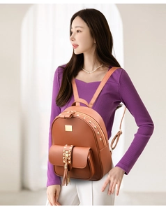 Brown PU leather backpack with rivet accents and tassel shown on model side profile