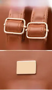 Detail of golden metal buckle and textured leather strap on brown backpack