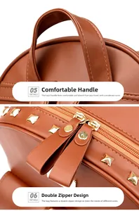Close-up of brown PU leather backpack with gold rivets and double metal zippers