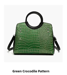 Detail of green crocodile pattern handbag with black handle and silver rivets