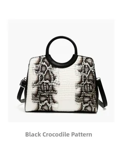 Close-up of black and white gradient croc pattern leather on a crossbody handbag