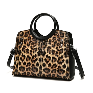 Fashionable leopard print handbag with black leather trim and silver metal rivets