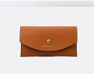 Detail of a brown leather long wallet with a gold snap closure and gold embossed logo