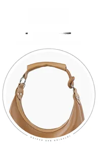 Detail view of brown lychee texture bag with detachable knotted leather strap and silver rings