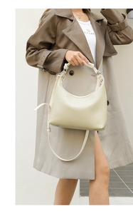 Detail of hobo bucket bag in cream pebbled leather with silver hardware and shoulder strap
