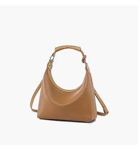 Macro detail of caramel brown textured leather hobo bag with silver metallic hardware