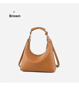 Detail of a brown leather hobo bag with pebble texture and knotted strap design