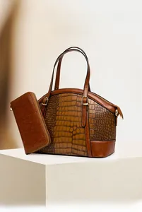 Detail of vintage brown crocodile embossed handbag with luxury gold hardware set