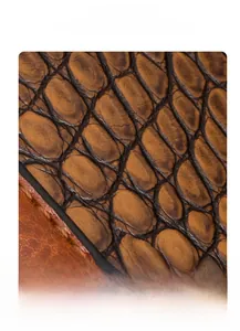 Close-up of brown crocodile embossed leather with high gloss finish and deep texture