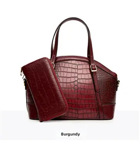 Close-up of wine red crocodile embossed texture on luxury shoulder bag and wallet set