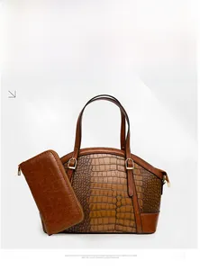 Detail view of brown crocodile embossed tote bag and matching long zipper wallet set