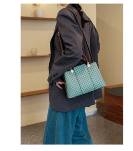 Borsa tote con stampa floreale e manici in pelle marrone portata a spalla in una stanza