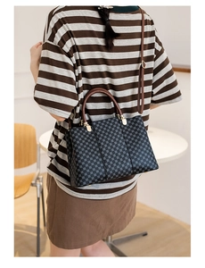 Vista posteriore della modella con borsa tote vintage stampata e manici in pelle marrone