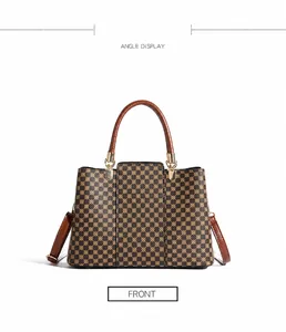 Vista dettagliata di una borsa vintage con stampa geometrica e manici in pelle marrone