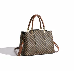 Vista laterale obliqua della borsa tote vintage con finiture in pelle e dettagli oro