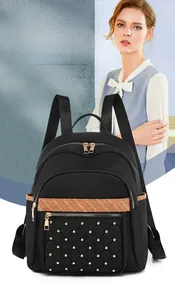 Detail of waterproof nylon backpack with gold rivet quilted pocket and woven ribbon strap