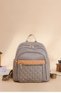 Detail of grey Oxford backpack featuring quilted leather panel and gold studs detail