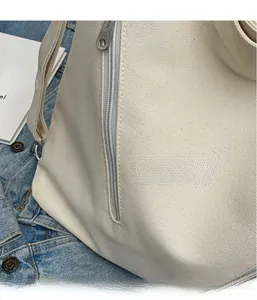 Close-up of durable white canvas shoulder bag featuring reinforced straps and smooth zipper