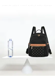 Lightweight black oxford fabric backpack for women weighing only 0.4kg shown on scales