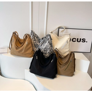 Close-up of large canvas hobo bags in solid earth tones and zebra pattern with metal zips