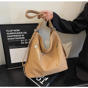Close-up of canvas tote bag featuring dual vertical zip pockets and adjustable strap