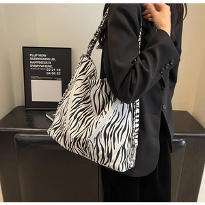 Detail of zebra print canvas tote featuring silver metal zippers and spacious structure