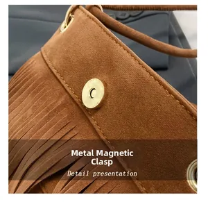 Dettaglio ravvicinato della fibbia magnetica dorata su borsa in pelle scamosciata marrone