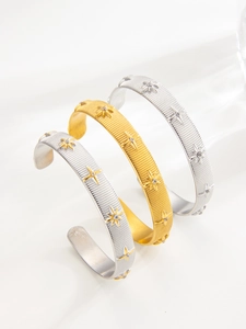Detail view of C-shaped adjustable bangles with star patterns and sparkling zircons