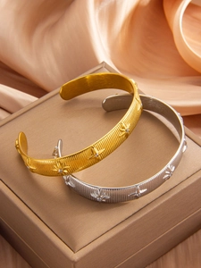 Detail of PVD 18k gold and silver hexagram star bangles on premium silk background
