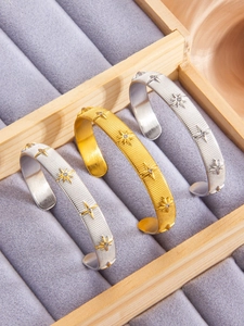 Detail of North Star brushed cuff bracelets with zircon in gold and silver finishes
