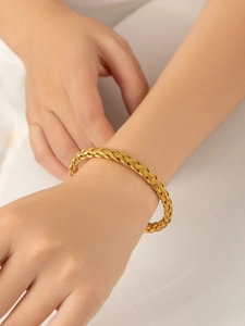 Macro detail of the 18k PVD gold plated woven titanium steel bracelet on model wrist
