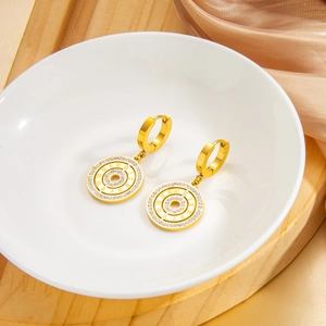 Gold Roman numeral hoop earrings with sparkling crystals on elegant white ceramic plate