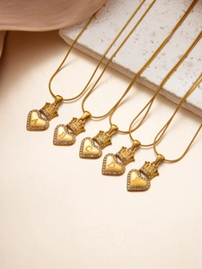 Macro shot of 18k gold heart necklaces with crystal crown and custom A-E initials