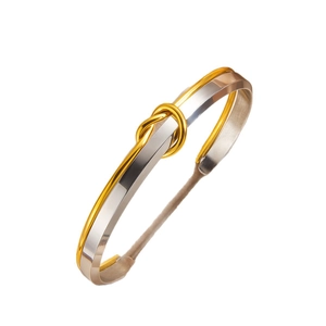 Minimalist adjustable mixed-metal knot bangle in 18k gold and polished stainless steel