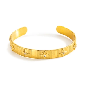 Adjustable golden PVD plated titanium cuff bracelet with brushed texture and starburst motifs