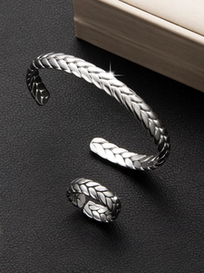 Detalle del conjunto de pulsera y anillo ajustable con diseño de trigo y brillo metálico