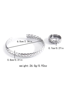 Detalle del conjunto de brazalete y anillo plateados con patrón de espiga y medidas