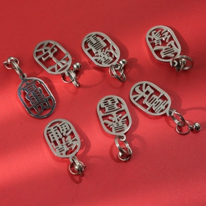 Macro detail of 304 stainless steel blessing charms with bells on a red background