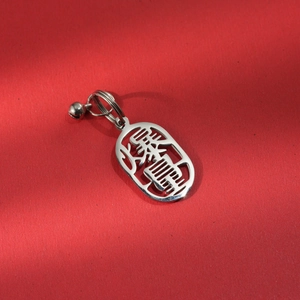 Macro view of silver 304 stainless steel 'Get Rich' pendant with a small bell