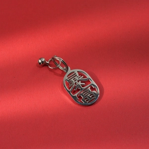 Close-up of stainless steel keychain featuring a wealth charm and a silver bell accessory