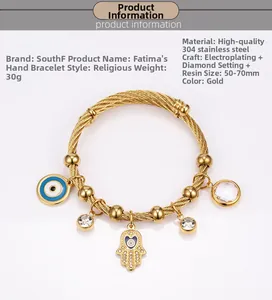 Macro detail of gold 18K stainless steel bracelet with Fatima Hand and Evil Eye charms