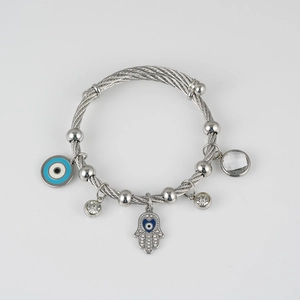 Detail of silver multi-layer wire bracelet with Hamsa Hand and Evil Eye charms