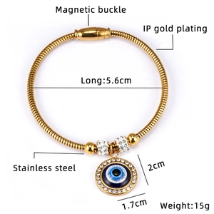 Macro detail of 18K gold plated snake bone bracelet with magnetic buckle and evil eye charm