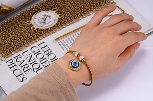 Detailed view of 18K gold plated snake chain bracelet with evil eye charm and zircon stones