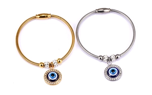 Detail of 18K gold and silver snake chain bracelets with crystal encrusted Evil Eye charms