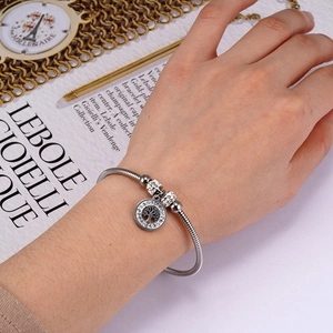 Silver snake chain bracelet with sparkling Tree of Life charm on a woman's wrist