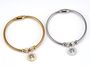 Detail of tree of life charm on snake chain bracelet with magnetic clasp and rhinestones