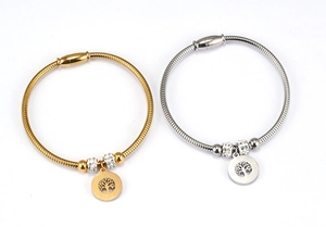 Close-up of gold and silver Tree of Life bracelets with snake chains and magnetic clasps