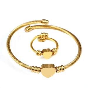 Macro shot of 18K gold plated steel cable jewelry set featuring heart pendants