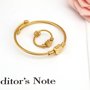 Detailed view of gold cable wire jewelry set with heart charms on white background